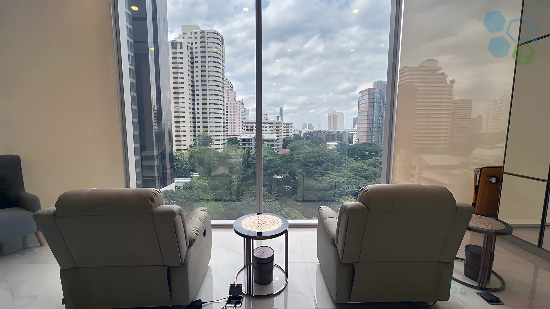 Private consultation room with recliner seating and Bangkok skyline view